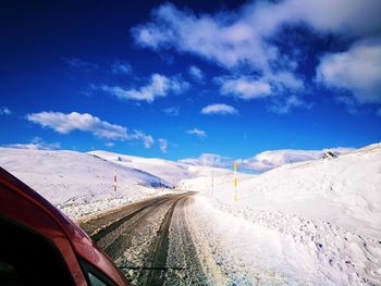 Road amidst snowcapped mountains against sky