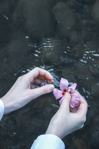 High angle view of woman hand holding water in lake