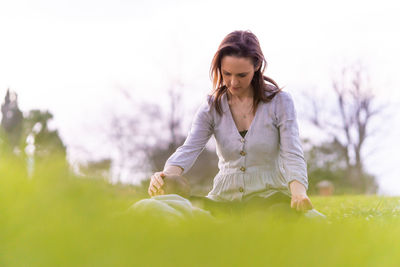 Young woman with arms raised on field