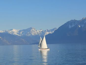 Sailing boats against snowcapped mountains