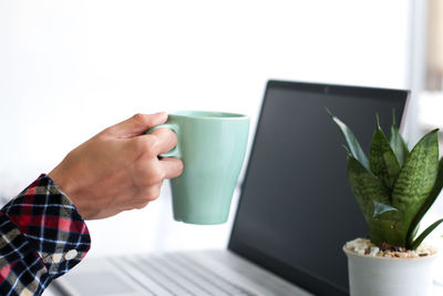 Midsection of woman holding coffee cup