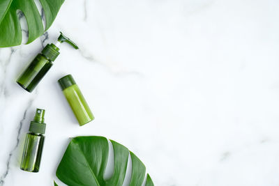 Close-up of green bottle on white table