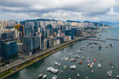 High angle view of city buildings by sea against sky