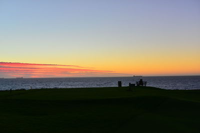 Scenic view of sea against clear sky during sunset