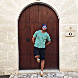 Full length of man standing against door