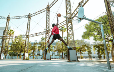 Low angle view of man standing on swing