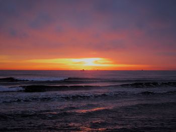 Scenic view of sea against romantic sky at sunset