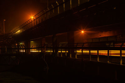 Illuminated bridge against sky at night
