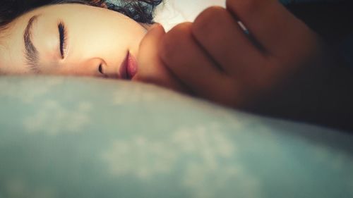 Close-up of girl sleeping on bed