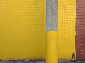 Pole against yellow wall