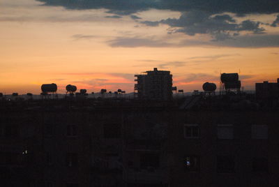 Silhouette cityscape against sky during sunset