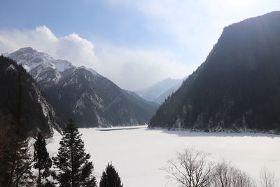 Scenic view of lake and mountains against sky during winter