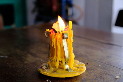 Close-up of burning candle on table