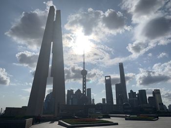 Modern buildings in city against cloudy sky