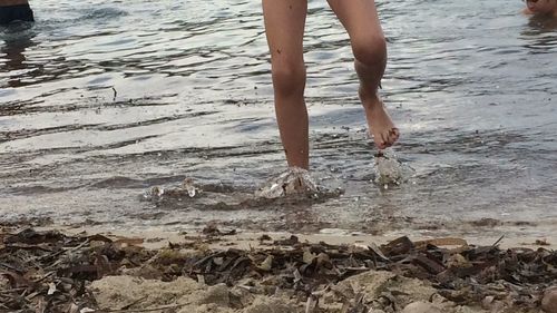 Low section of child standing on beach