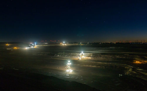 Illuminated cityscape against sky at night