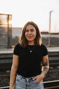 Smiling woman standing at train station platform