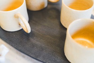 Handmade mugs on the black slate stone surface