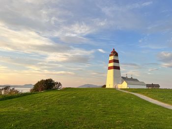 Lighthouse by sea against sky