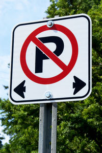 Low angle view of road sign against trees