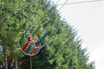 Adventure climbing high wire park - people on course in mountain helmet and safety equipment