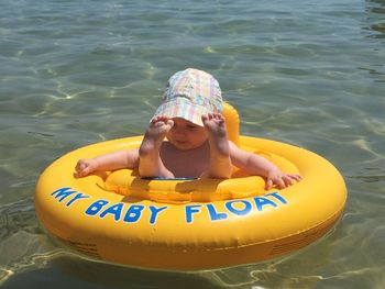 Cute baby girl sitting in inflatable on water