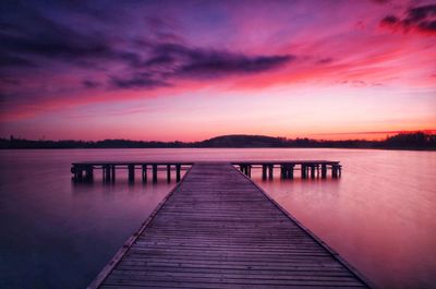 Pier over lake against sky during sunset