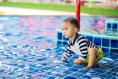 Boy sitting in swimming pool