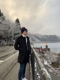 Woman standing on snow against sky