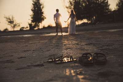 Close-up of sandals on shore of beach 