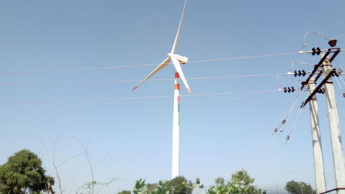 Low angle view of windmill against clear blue sky