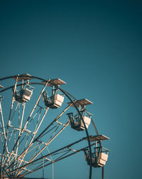 Low angle view of electricity pylon against clear blue sky