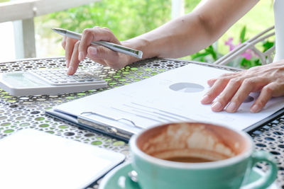 Hand holding coffee cup on table