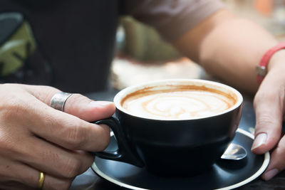 Cropped image of hand holding coffee cup