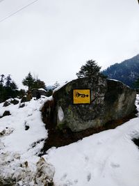 Information sign on snow against sky