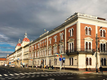 People on street by building against sky