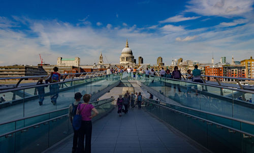 Rear view of people walking on bridge