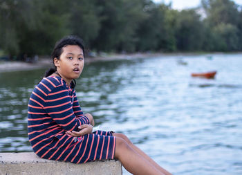 Portrait of boy sitting on lake