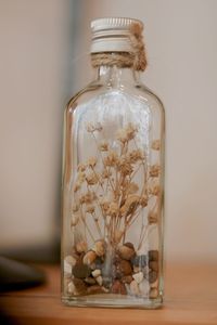 Close-up of glass jar on table against wall