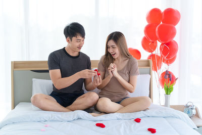 Young couple sitting on bed