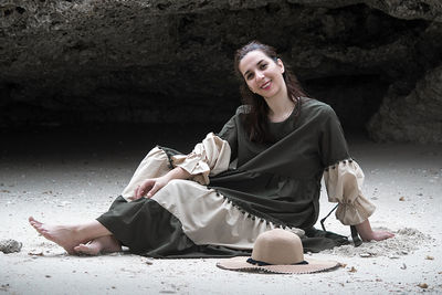 Portrait of young woman sitting on rock