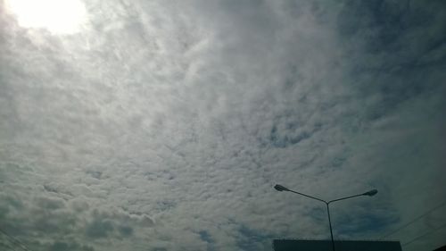 Low angle view of street light against cloudy sky