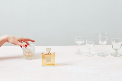 Still life of woman's hand, glass and perfume