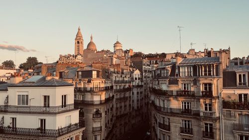 Buildings in city against clear sky