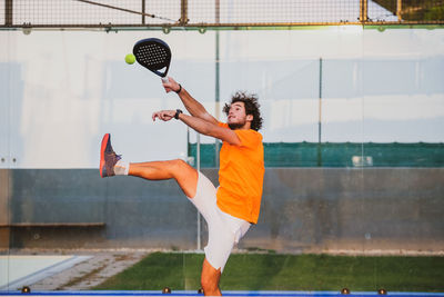 Full length of young man playing tennis
