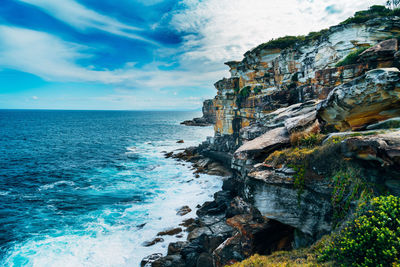 Scenic view of mountains by sea against sky