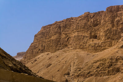 Low angle view of rocky mountains against clear sky