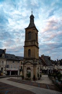 Low angle view of clock tower amidst buildings in city against sky