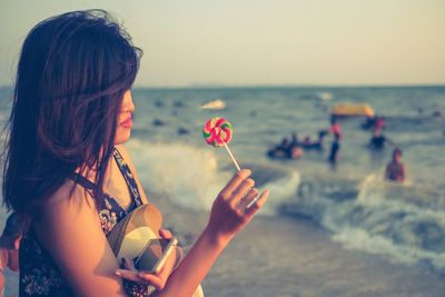 Woman holding candy at beach