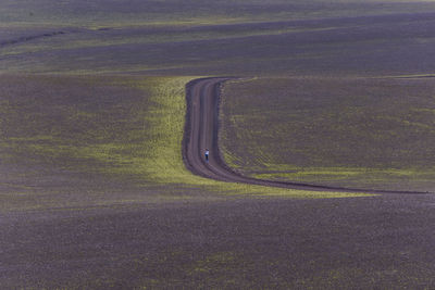 Woman standing in the middle of nowhere on dirt road in highlands